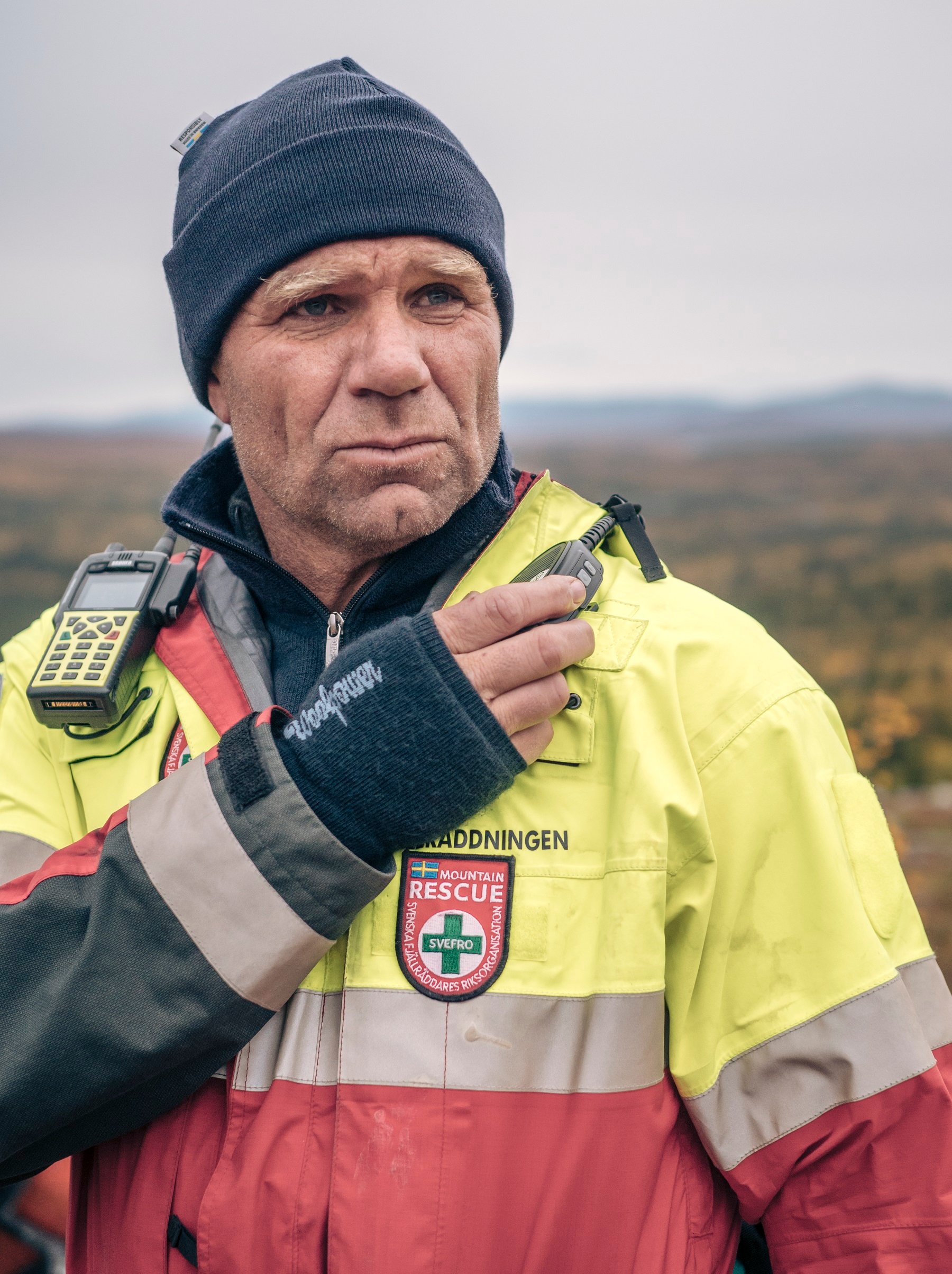 Fotograf: Lavinprognoser.se Närbild på Rickard Svedjesten som står i en gul räddningsjacka och svart mössa.